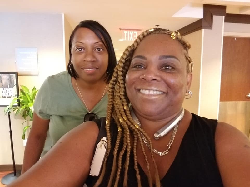Two cousins smiling together in a hotel lobby