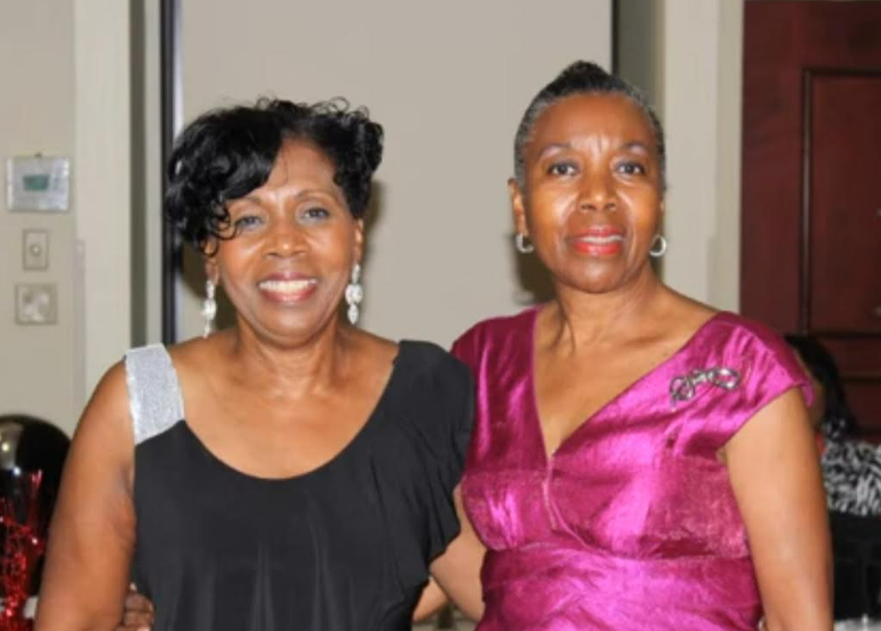 Two women smiling together at a reunion banquet