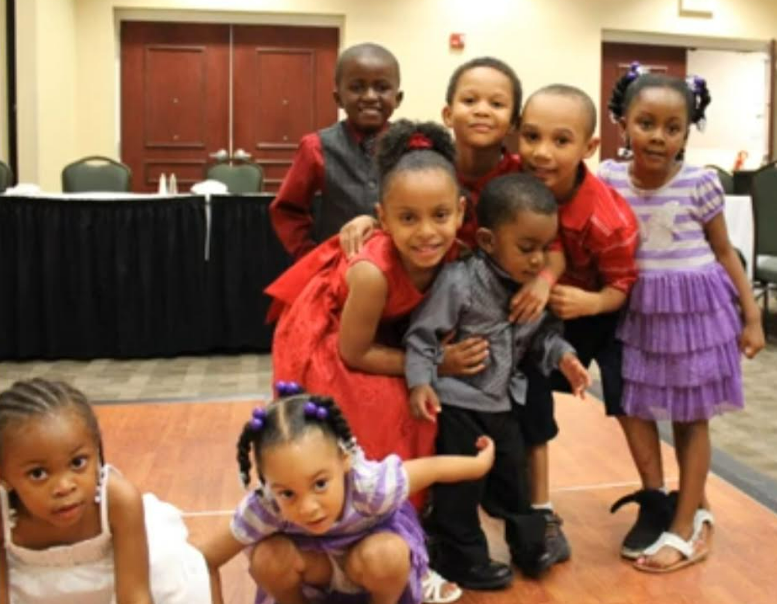 Young children hugging and laughing together at the reunion