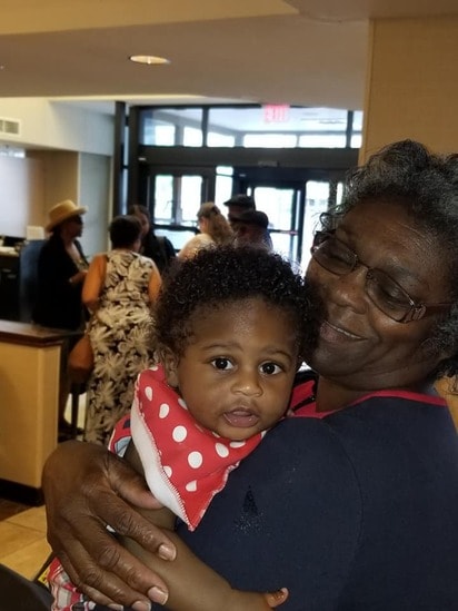 Grandmother holding a baby at the reunion hotel lobby