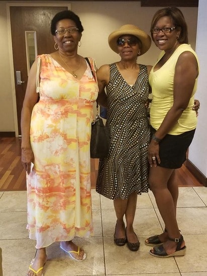 Three women posing together at a reunion gathering
