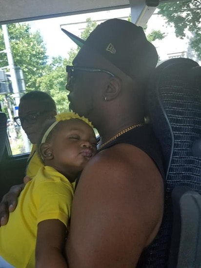 Father holding sleeping baby on the reunion bus tour