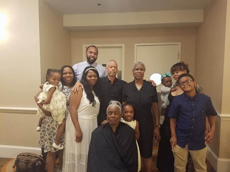 Multi-generational family group photo at a reunion banquet