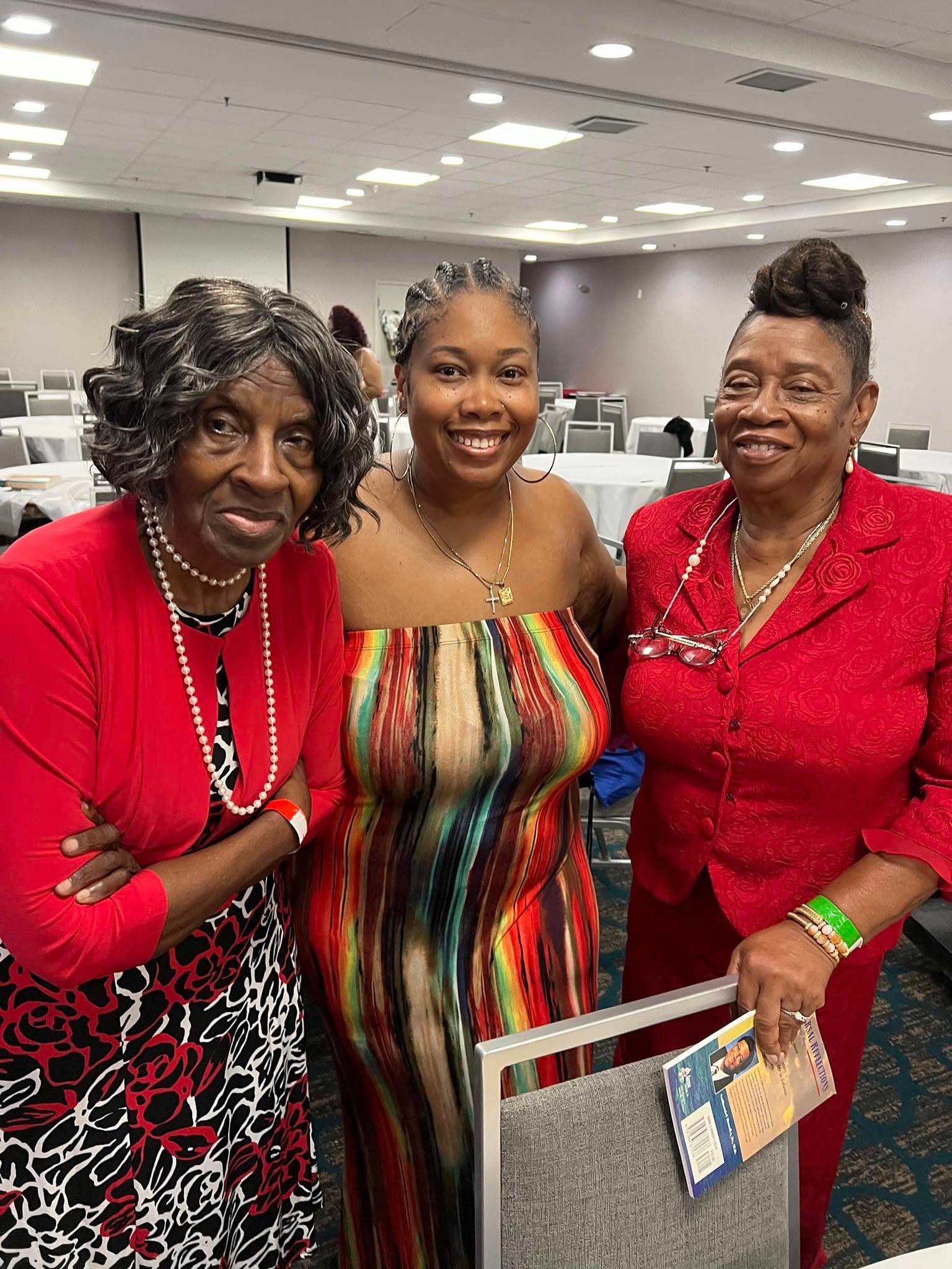 Three generations of women smiling together at a reunion banquet