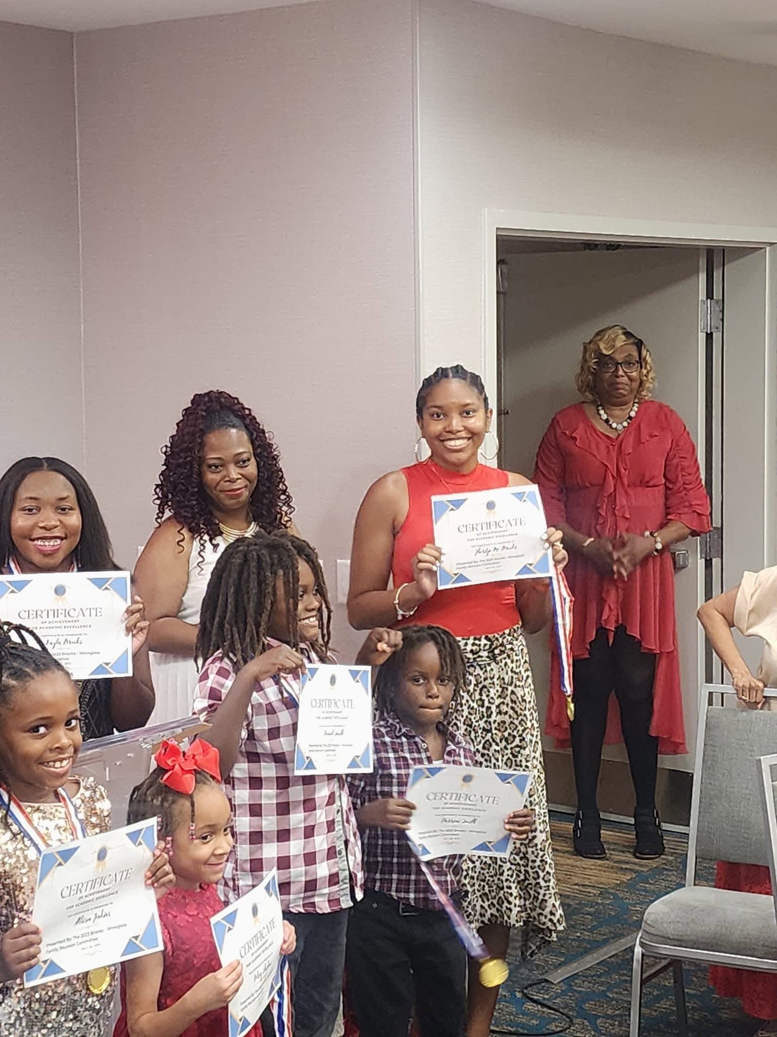 Youth and young adults holding certificates of achievement at the reunion